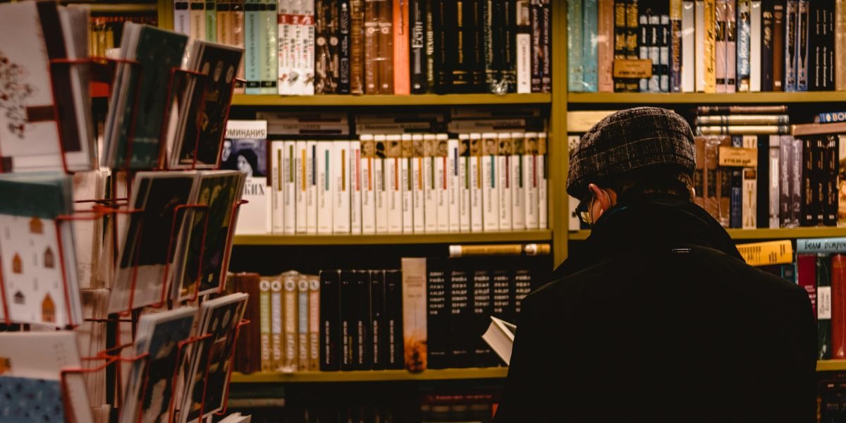 A reader explores a well-organized humor section, looking for specific genres or staff picks.