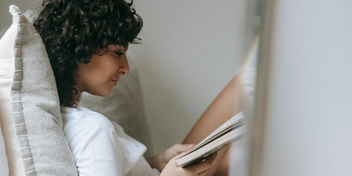 A reader immersed in a book that combines wit, intelligence, and engaging storytelling.