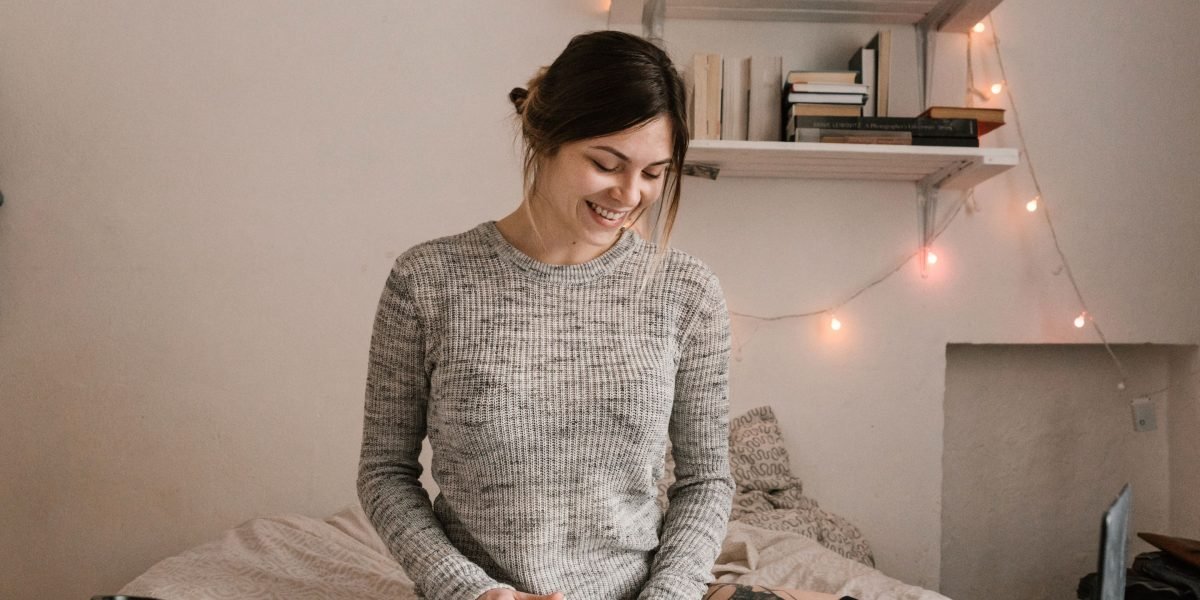 A person happily browsing book titles and covers on a tablet, enjoying the search for new reads.